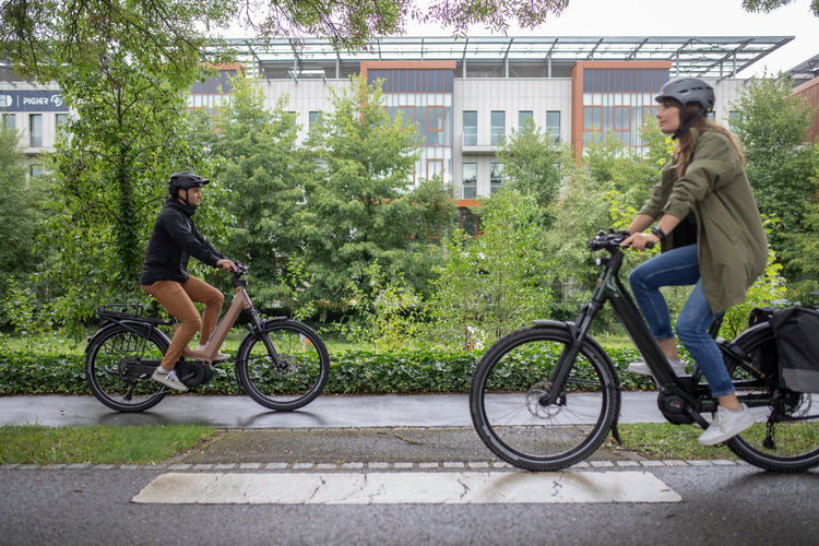 Moustache Xroad FS electric bikes being ridden on an urban cycle path